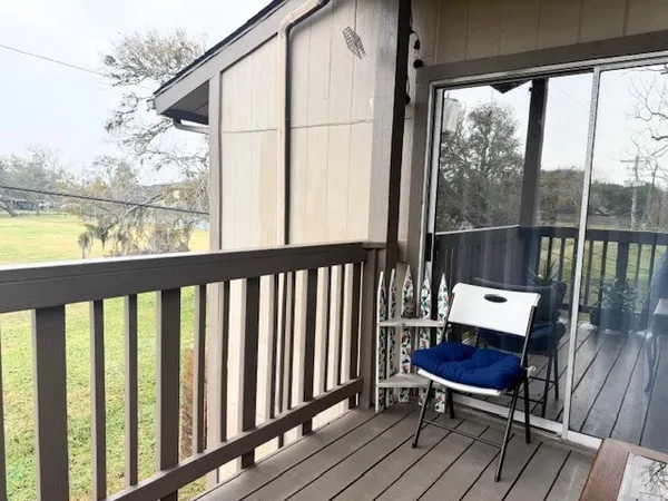 a view of a balcony with chair and wooden floor