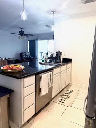 a kitchen with granite countertop a sink a stove and cabinets