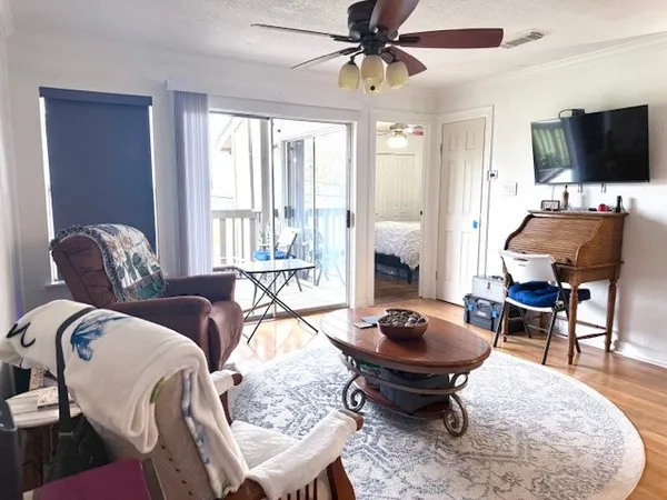 a living room with furniture a flat screen tv and a large window