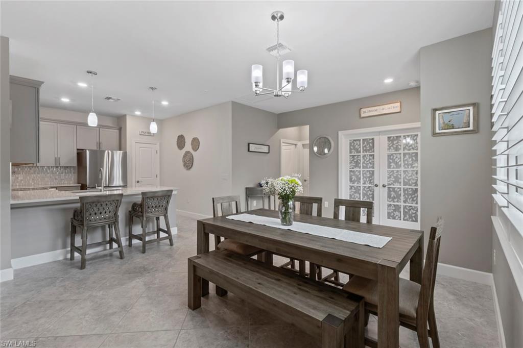 5825 Mayflower Way Ave Maria, FL 34142 - Photo 16 of 50 a view of a dining room with furniture and a chandelier
