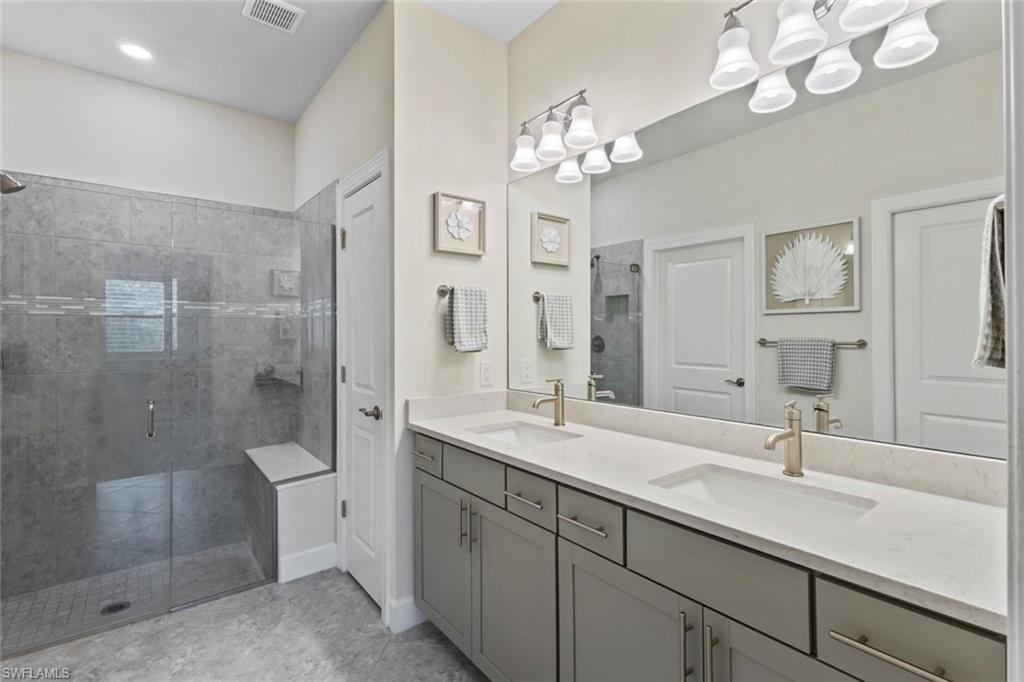5825 Mayflower Way Ave Maria, FL 34142 - Photo 20 of 50 a bathroom with a double vanity sink mirror and shower