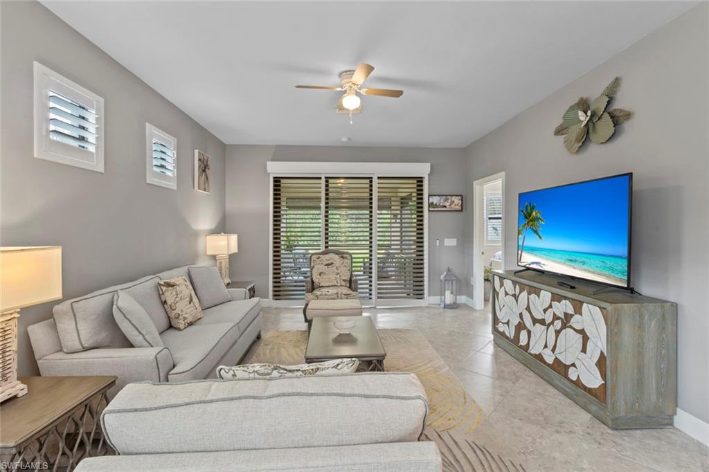 5825 Mayflower Way Ave Maria, FL 34142 - Photo 5 of 50 a living room with furniture a flat screen tv and a floor to ceiling window