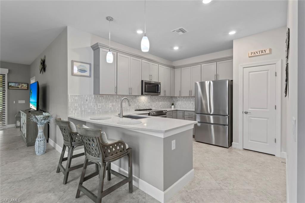 5825 Mayflower Way Ave Maria, FL 34142 - Photo 9 of 50 a kitchen with refrigerator a sink a stove and chairs