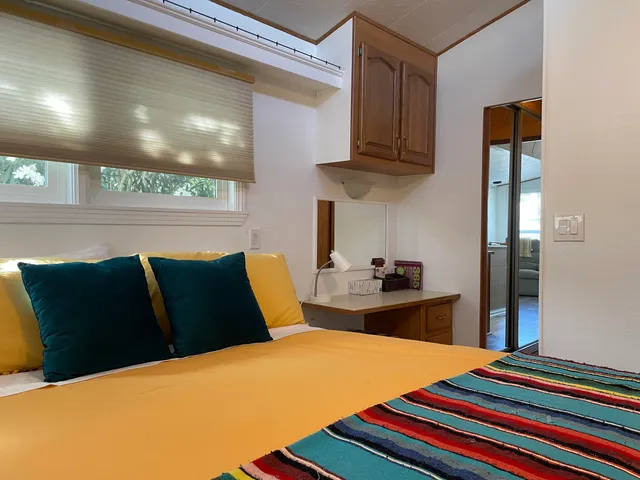 a bedroom with a bed and dresser with mirror