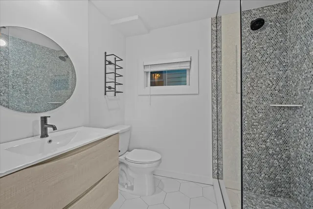 a bathroom with a sink a toilet and shower