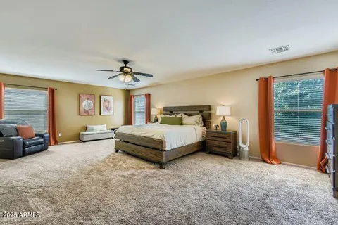 a spacious bedroom with a bed a couch and dresser