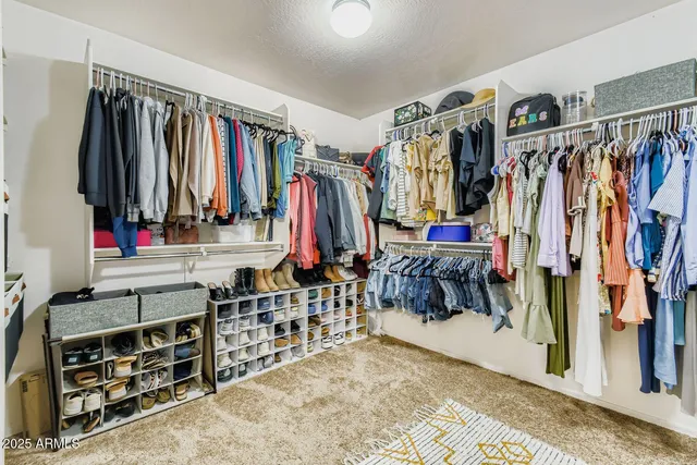 an empty room with chandelier fan and windows