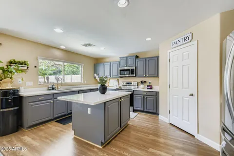 a kitchen with granite countertop a sink stove and refrigerator