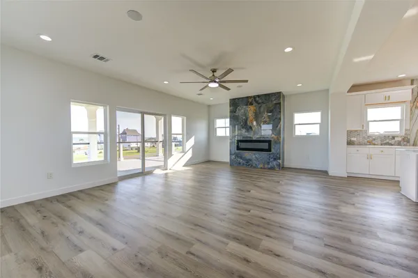a view of an empty room with window and wooden floor