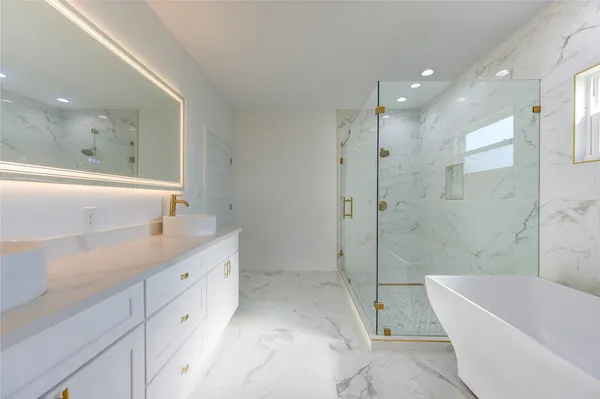 a bathroom with a tub sink shower and mirror