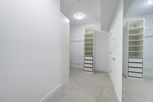 a view of walk in closet with empty racks