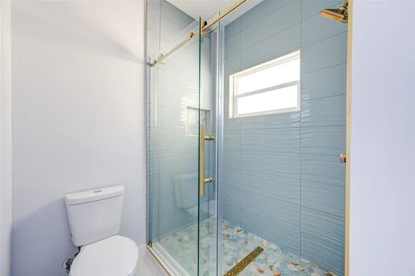 a bathroom with a toilet and a shower