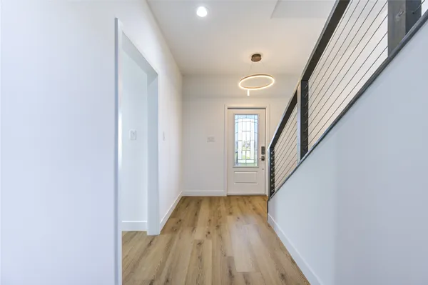 a view of a hallway with wooden floor and staircase