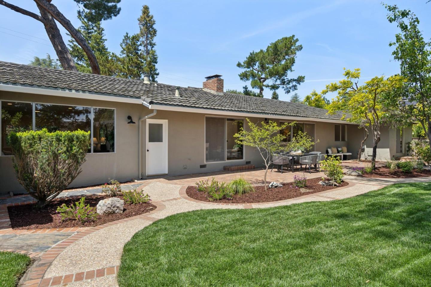755 Santa Rita Avenue Los Altos, CA 94022 - Photo 42 of 50 a backyard of a house with table and chairs potted plants and a large tree