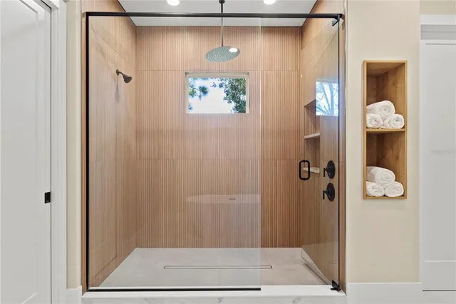 a bathroom with a shower and mirror