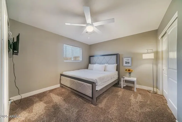 a spacious bedroom with a bed and a chandelier