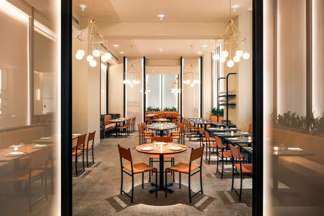 a dining room with furniture and a floor to ceiling window