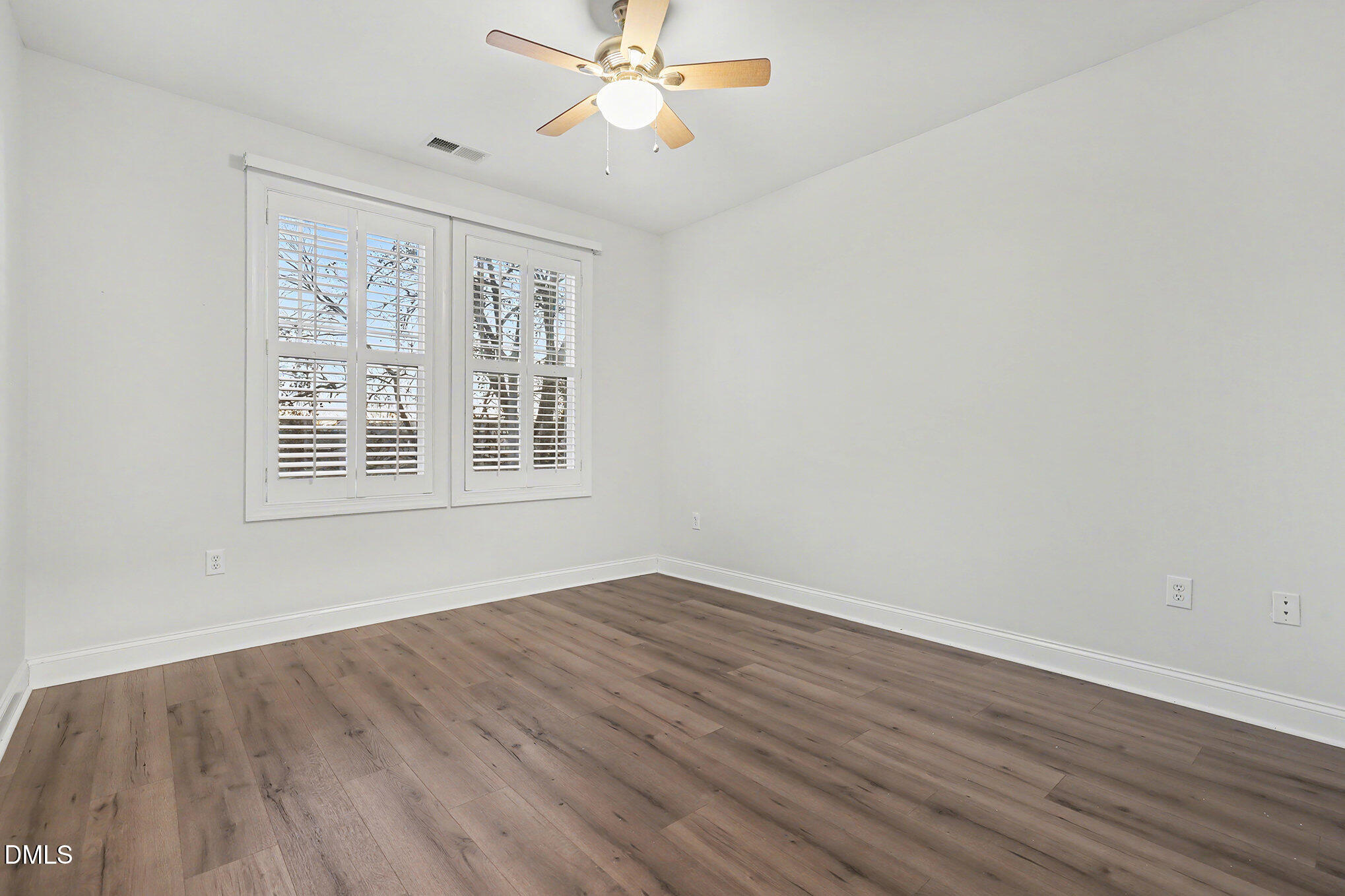 2810 Bedford Green Drive, Unit 207 Raleigh, NC 27604 - Photo 11 of 20 a view of an empty room with wooden floor and a window