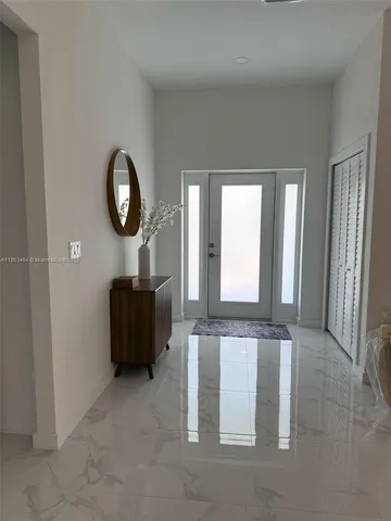 an empty room with mirror and windows