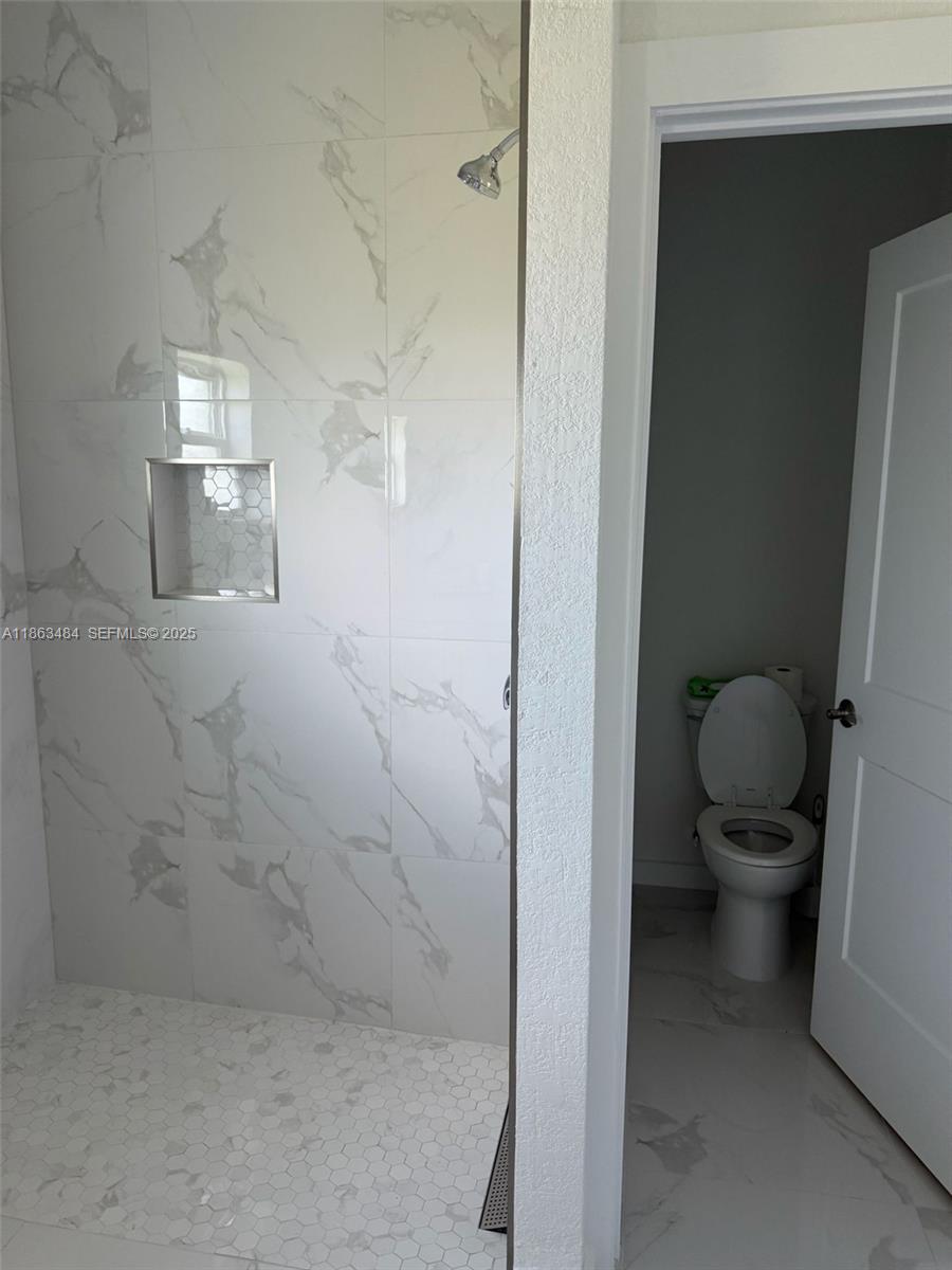 63 Coxswain Circle, Unit 63 Placida, FL 33946 - Photo 9 of 12 a bathroom with a granite countertop toilet and a shower