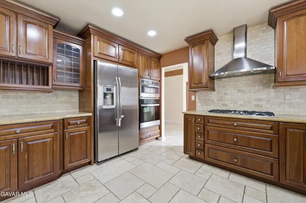 a kitchen with stainless steel appliances granite countertop a refrigerator and a sink