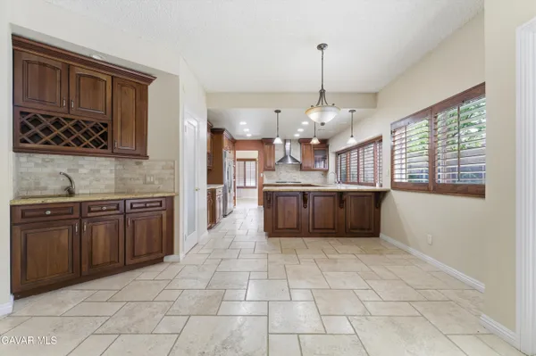 a large kitchen with stainless steel appliances kitchen island granite countertop a sink and cabinets