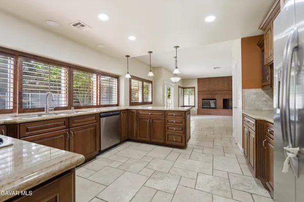 a large kitchen with a stove a sink dishwasher and a refrigerator