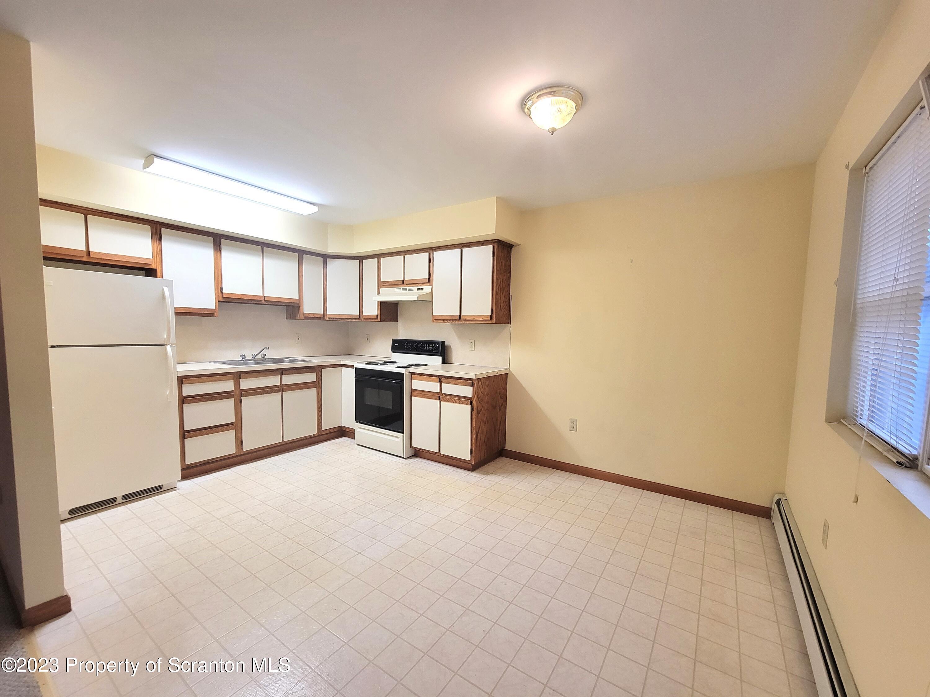 128 Mortimer Street, Unit 2R Dunmore, PA 18512 - Photo 3 of 7 a kitchen with stainless steel appliances a refrigerator and a sink