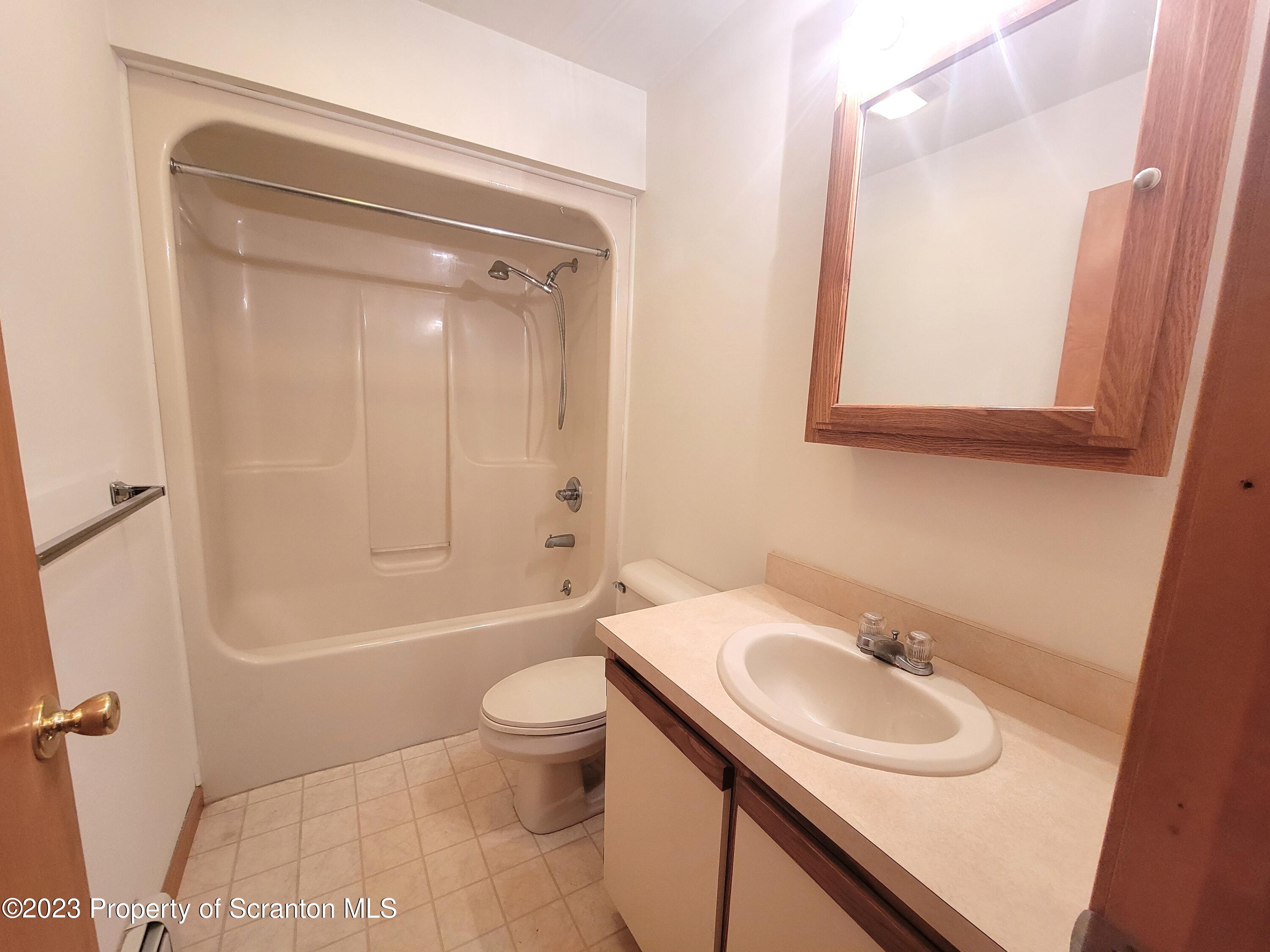 128 Mortimer Street, Unit 2R Dunmore, PA 18512 - Photo 4 of 7 a bathroom with a sink a toilet and shower