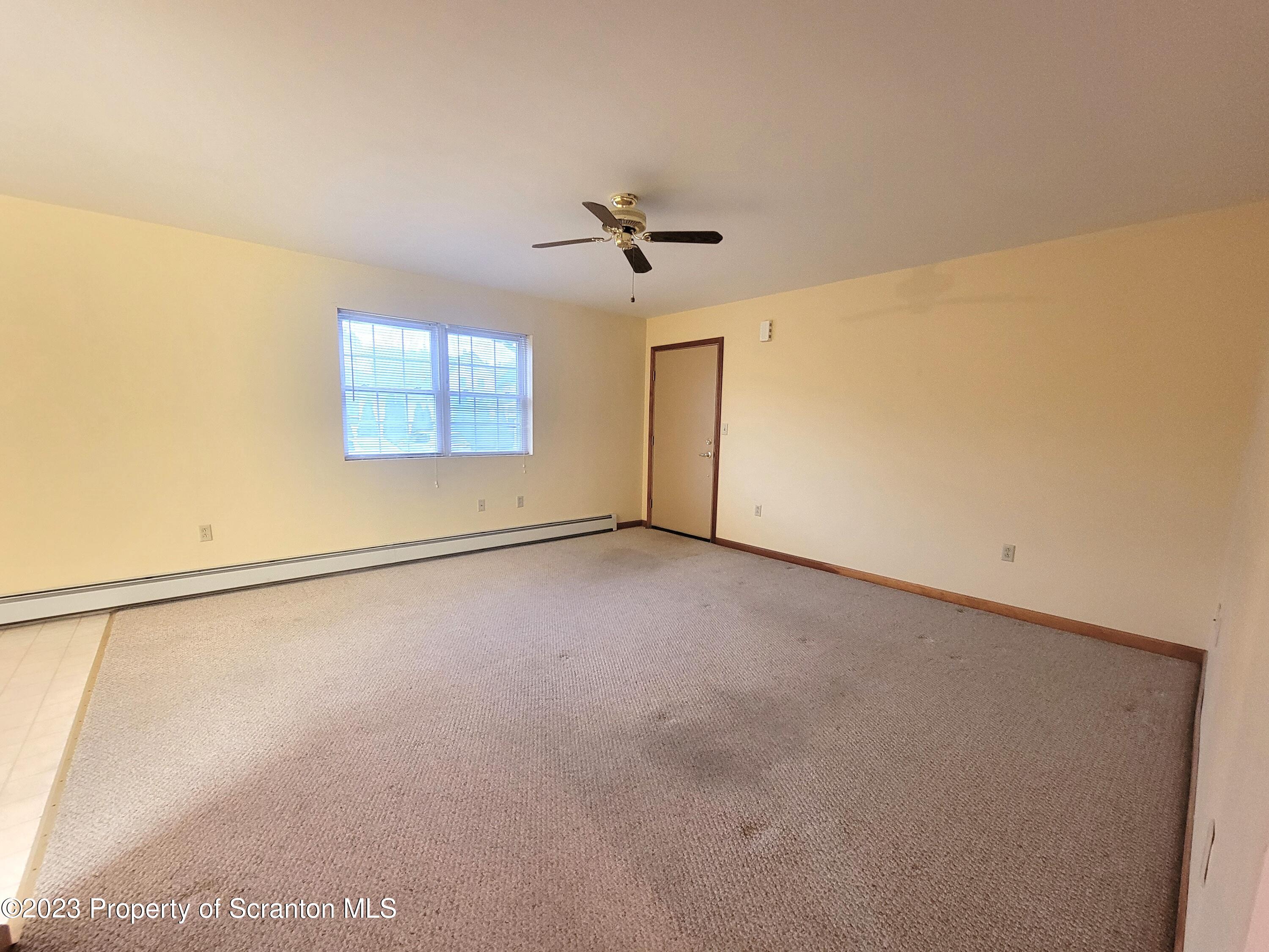 128 Mortimer Street, Unit 2R Dunmore, PA 18512 - Photo 7 of 7 an empty room with windows and ceiling fan