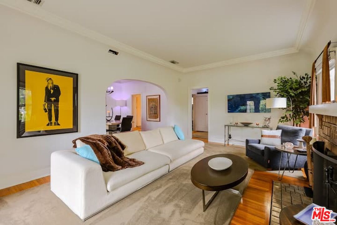 1203 South Rimpau Boulevard Los Angeles, CA 90019 - Photo 1 of 21 a living room with furniture a rug and a painting on the wall