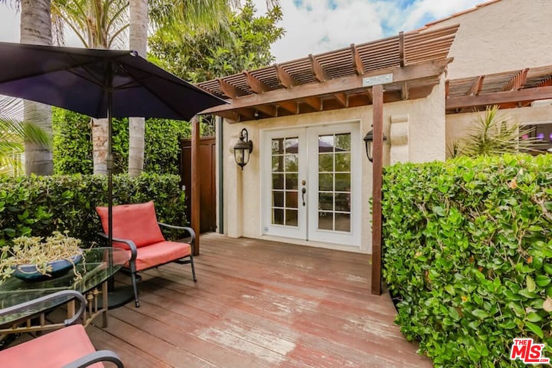 1203 South Rimpau Boulevard Los Angeles, CA 90019 - Photo 13 of 21 a patio with a table and chairs under an umbrella