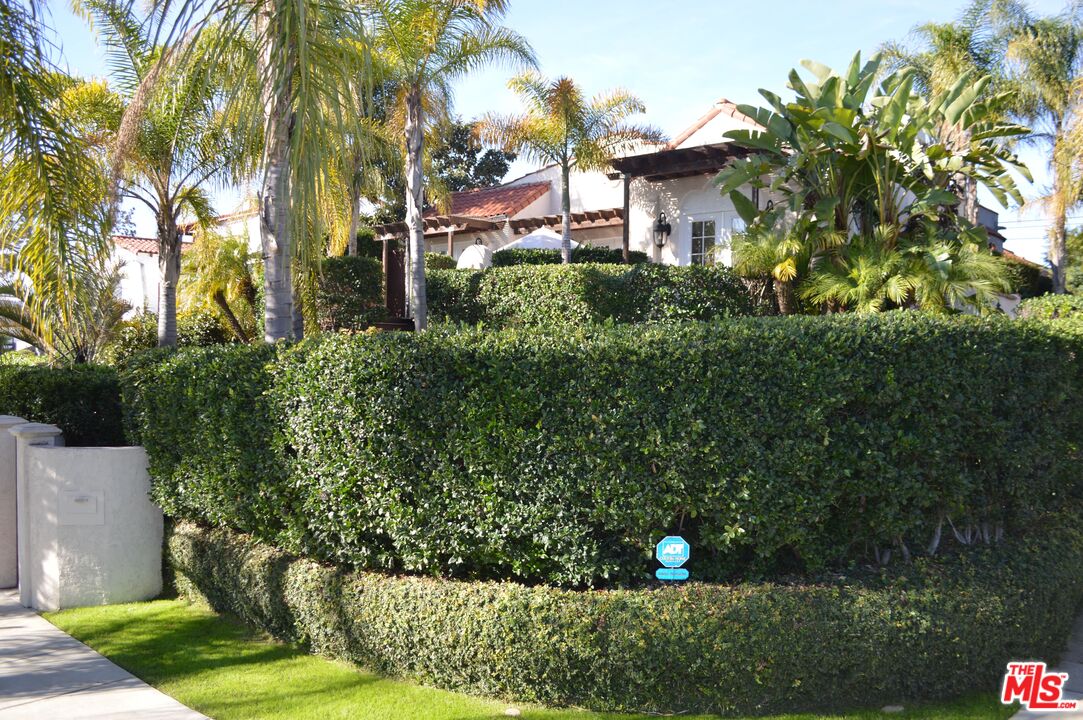 1203 South Rimpau Boulevard Los Angeles, CA 90019 - Photo 20 of 21 a view of a street with a building and trees in the background