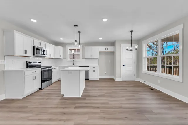 a view of kitchen with wooden floor and electronic appliances