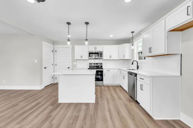 a kitchen with white cabinets white appliances and sink