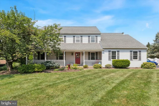 a front view of a house with yard and green space