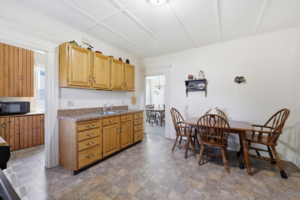 367 Broadway Street, Unit 1 Chicopee, MA 01020 - Photo 17 of 18 a kitchen with granite countertop a table chairs stove and cabinets
