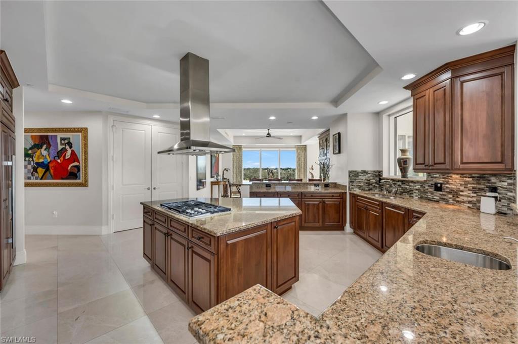 a kitchen with stainless steel appliances granite countertop a stove top oven and cabinets