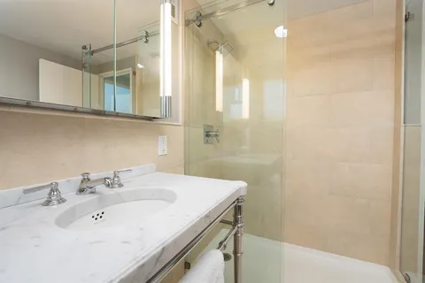 a bathroom with a sink a shower and a mirror