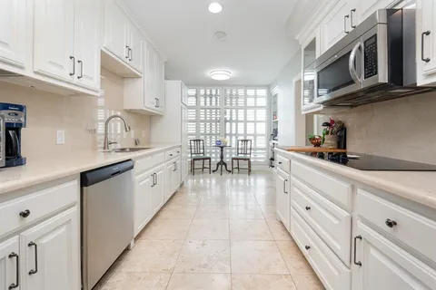 a kitchen with stainless steel appliances granite countertop a sink and cabinets