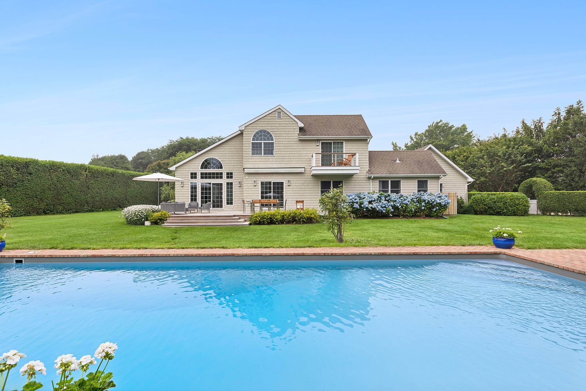 a view of pool and outdoor space in front of the house