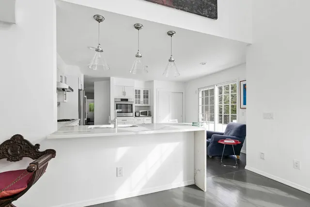 a living room with stainless steel appliances kitchen island granite countertop furniture and a window