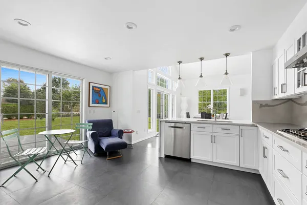 a living room with furniture a flat screen tv and a large window