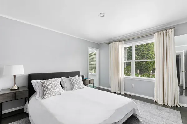 a large bed sitting in a bedroom next to a window