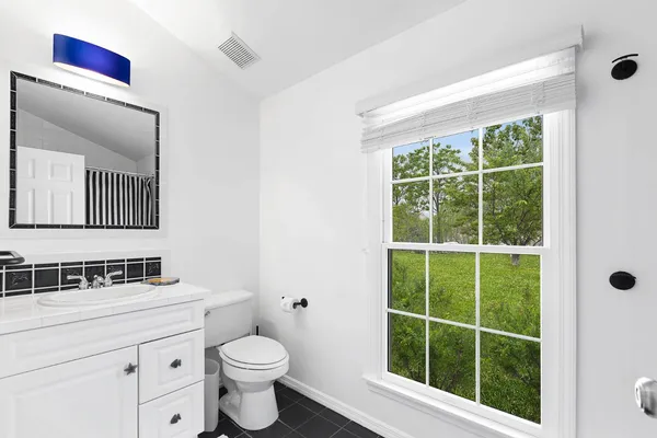 a bathroom with a toilet a sink and a window