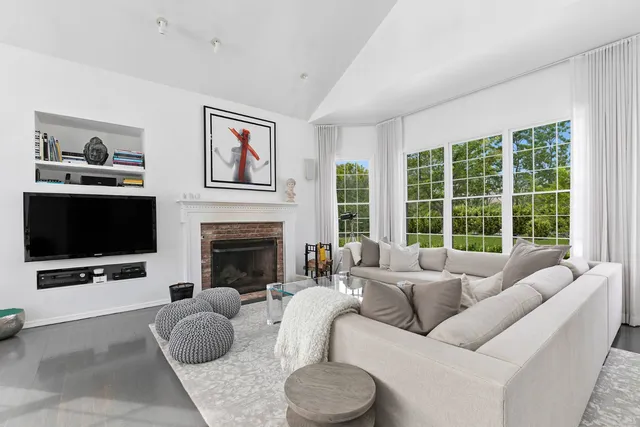 a living room with furniture a large window and a flat screen tv