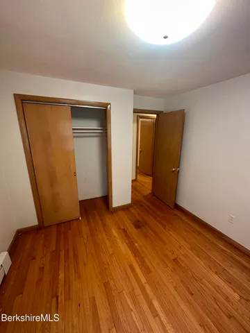 an empty room with wooden floor and closet