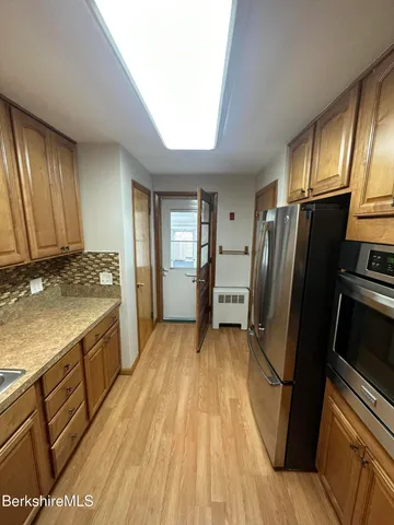 a kitchen with a refrigerator sink and cabinets