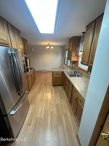 a kitchen with granite countertop a refrigerator stove and sink