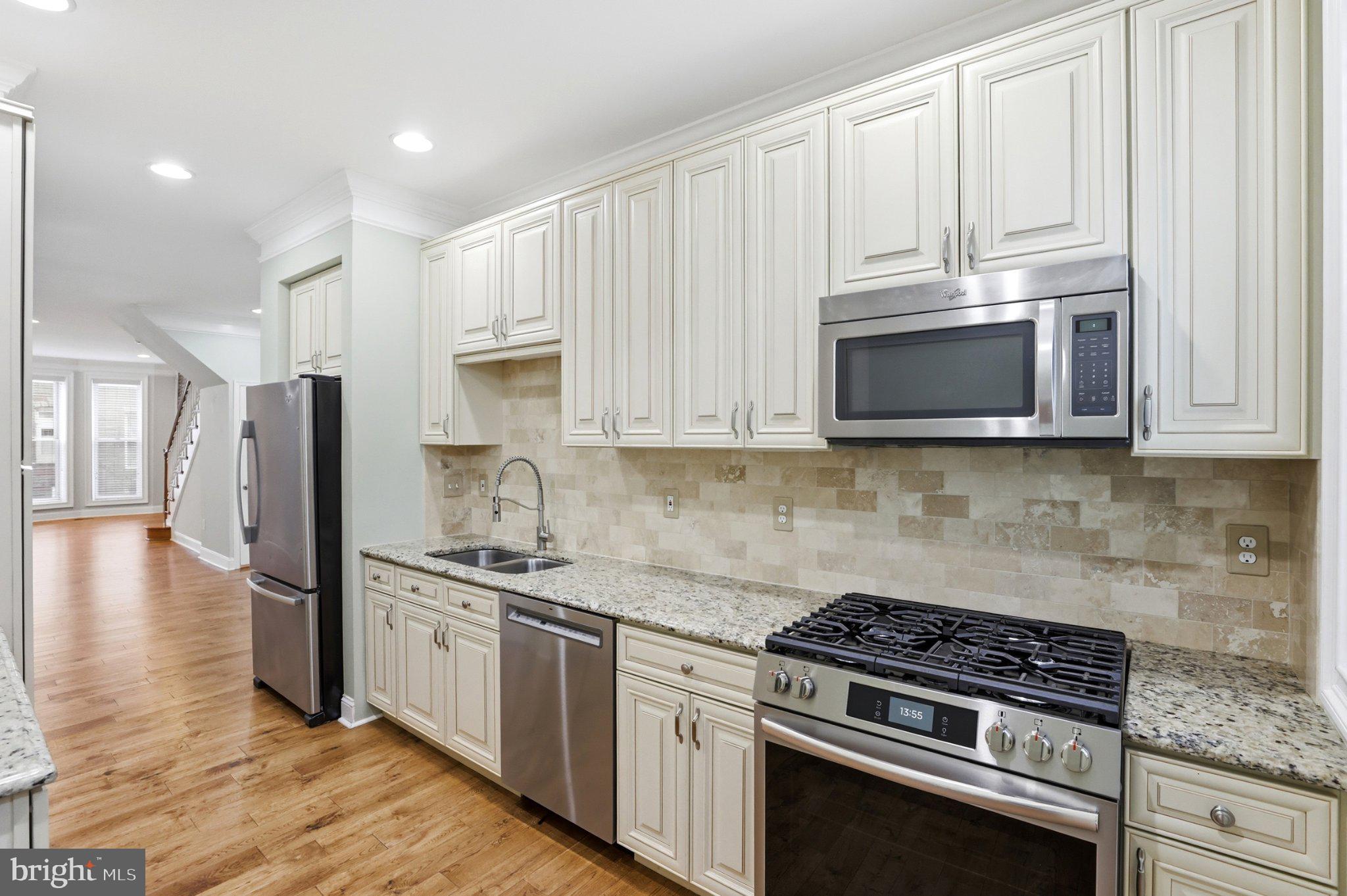 222 South Exeter Street Baltimore, MD 21202 - Photo 9 of 41 a kitchen with stainless steel appliances granite countertop a stove a refrigerator and a microwave